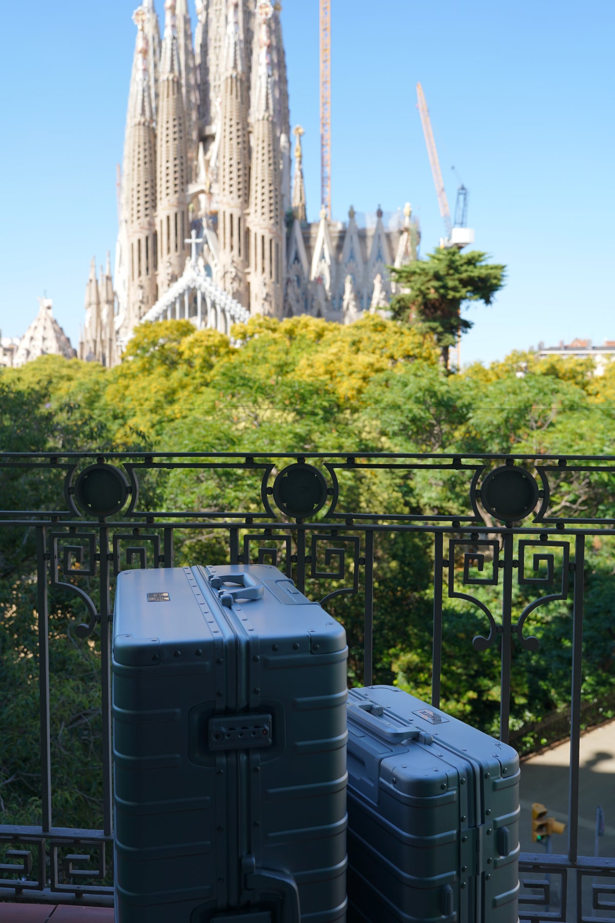 Two Gunmetal Grey FORTE cases on a balcony facing the Sagrada Família in Barcelona