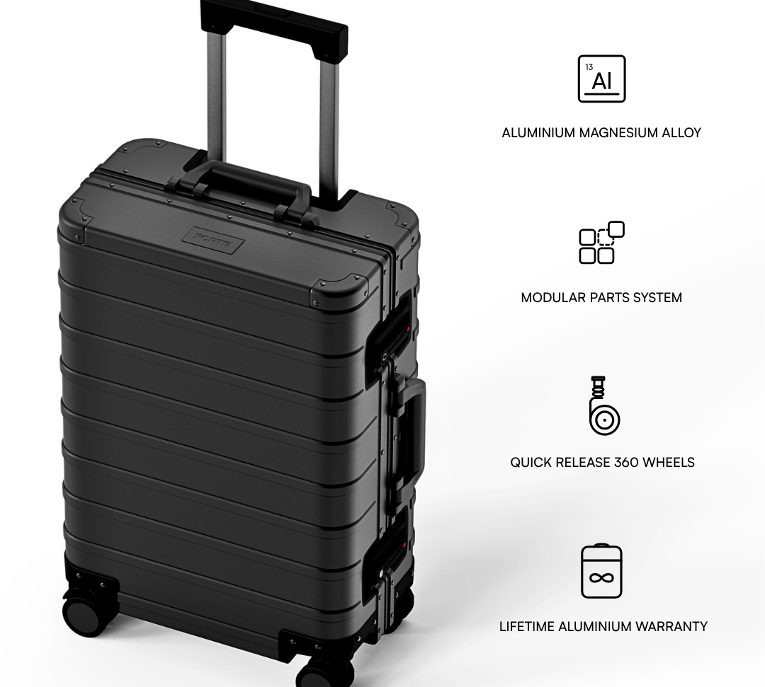 A black hard-shell rolling suitcase shown on a light gray background with feature callouts and text describing aluminium magnesium alloy construction, modular parts system, quick release 360 wheels, and lifetime aluminium warranty.
